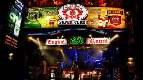 Nightlife scene at Engine Room Super Club in Kuta Bali with colorful neon lights, party atmosphere, and visitors walking at night.