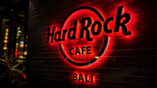 Hard Rock Cafe Bali neon sign glowing on a brick wall at night in Kuta Bali.