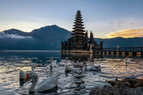 A serene view of Pura Segara Ulun Danu Batur and Jati Batur Temple, featuring traditional Balinese temple architecture, tranquil lakeside scenery, misty mountain backdrops, and a peaceful spiritual atmosphere in the Kintamani highlands.
