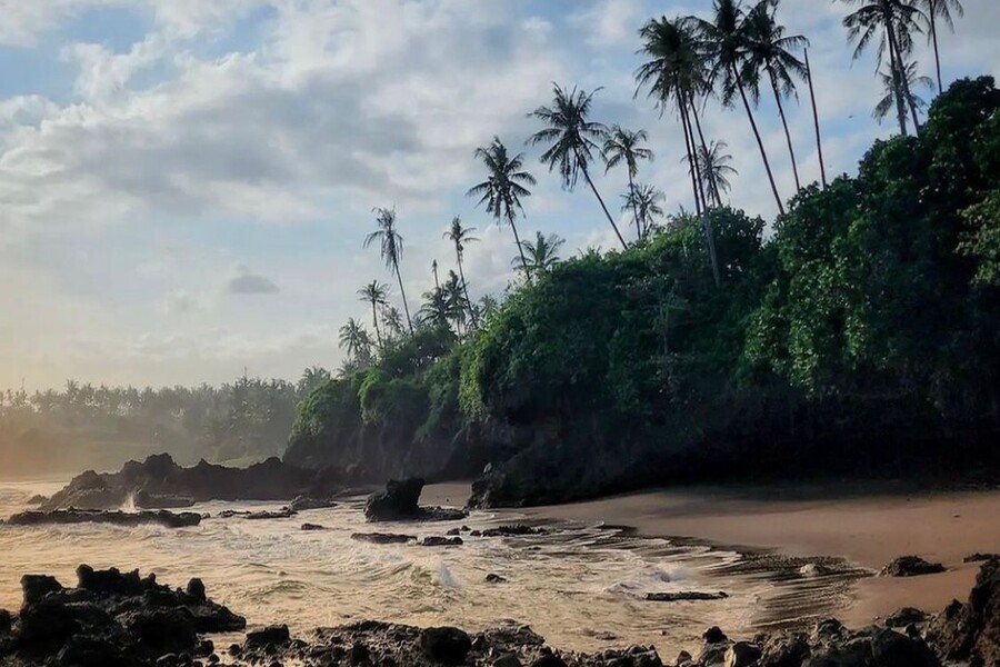 Scenic view of Soan Galuh Beach with rugged coastline and black sand in Tabanan, Bali.