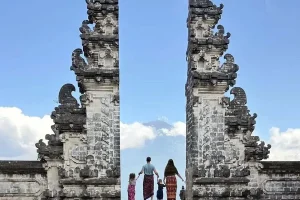 A family posing at the Lempuyang Temple split gate, a popular spot among Bali top attractions for photography and scenery | balitouristic.com