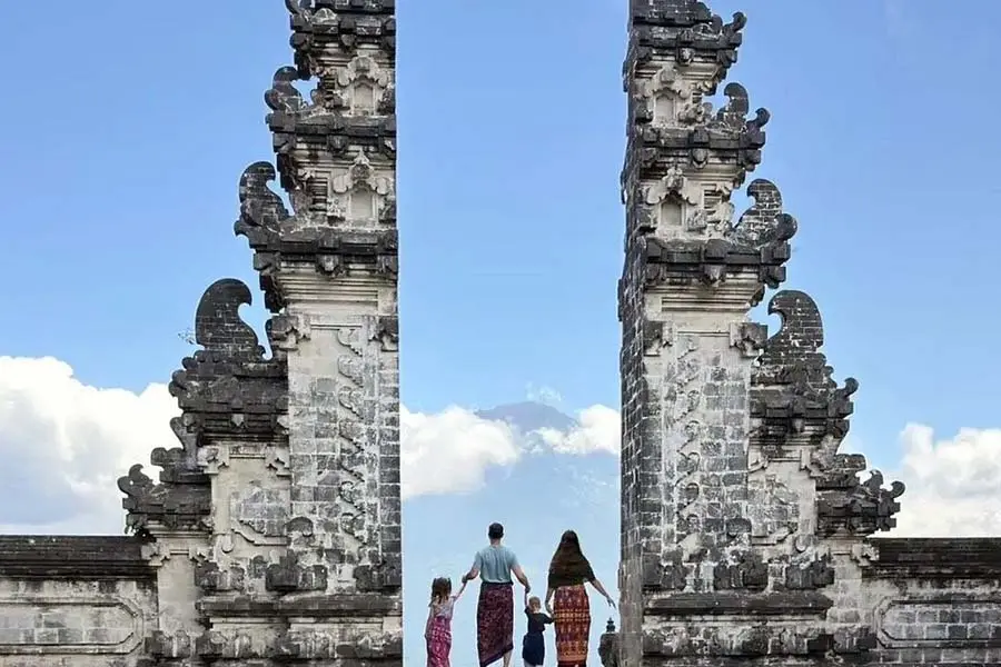 A family posing at the Lempuyang Temple split gate, a popular spot among Bali top attractions for photography and scenery | balitouristic.com