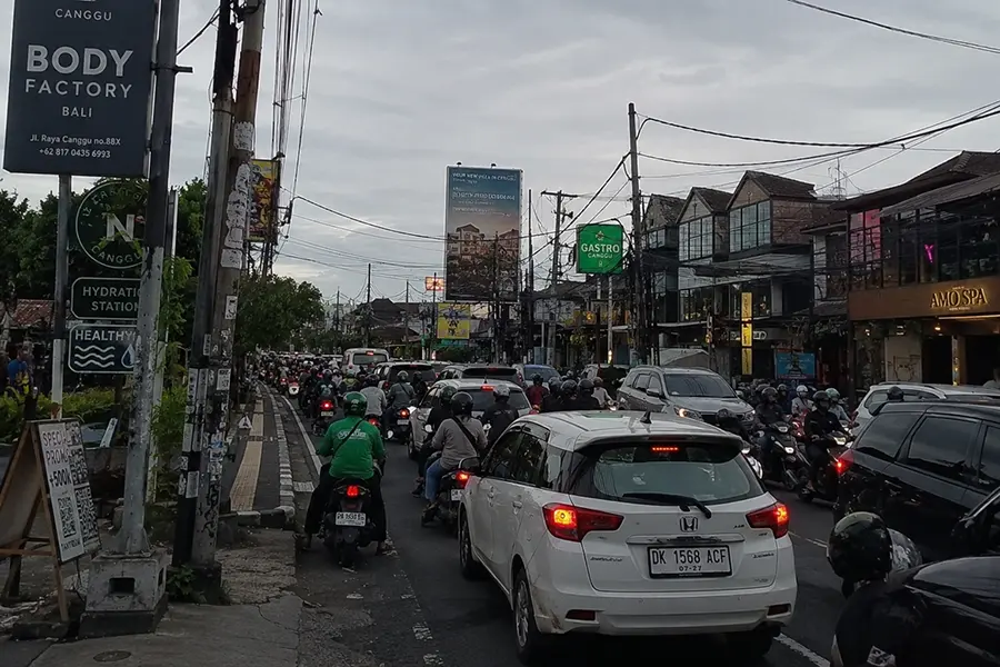 Heavy traffic on a busy Canggu road with cars and motorbikes during peak hours in Bali.