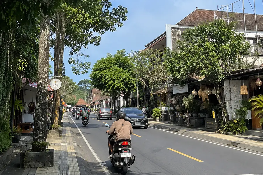 busy street in Ubud with cars and motorcycles, showcasing the vibrant atmosphere of self-drive trips in central Bali | balitouristic.com