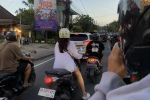 Tourists on a scooter in Bali traffic, a popular choice for flexible and local-style self-drive trips | balitouristic.com