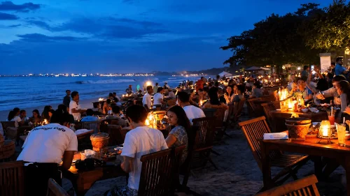 Crowded seafood dinner atmosphere at Jimbaran Bay Bali featured in a day Bali itinerary with visitors enjoying beachfront dining at sunset.