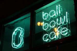 Vibrant nightlife scene in Kuta Bali with lively bars, neon lights, and people enjoying a great night out.