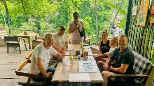 A group of tourists meeting a friendly local guide during an airport transfer from Ngurah Rai International Airport to Ubud, creating a welcoming and enjoyable start to their Bali journey.