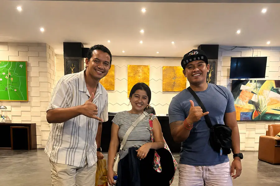 Happy travelers posing with their luggage after a successful and comfortable bali airport transfer to seminyak drop-off.