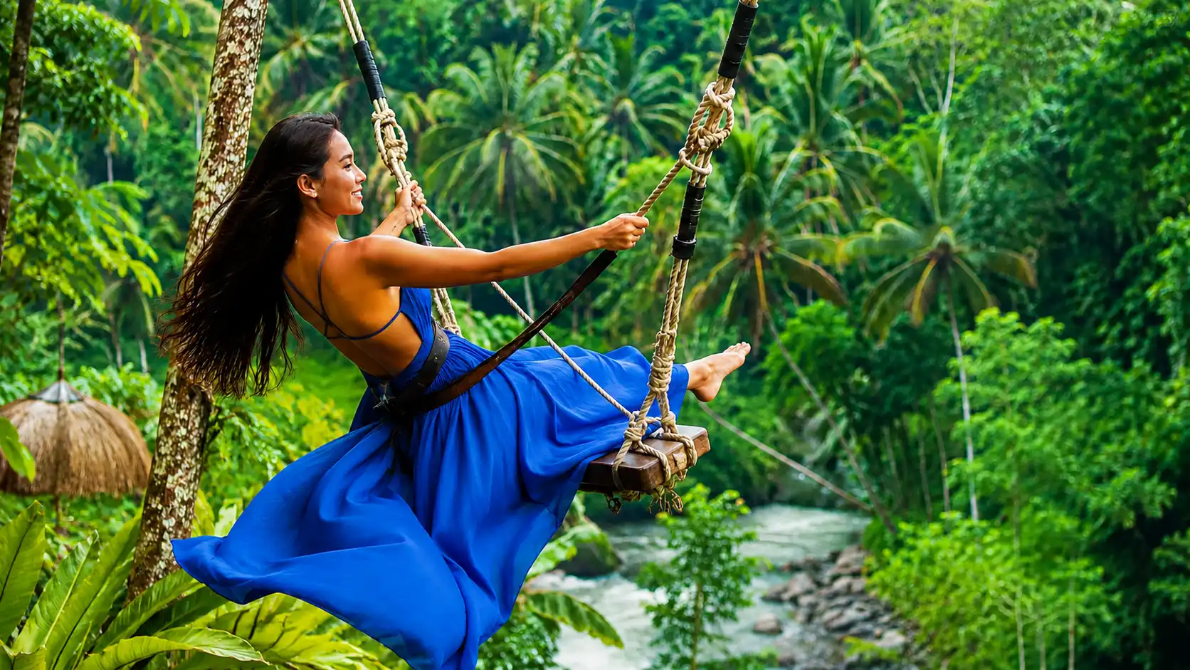 A woman wearing a flowing blue dress while posing on a jungle swing in Bali, surrounded by lush tropical scenery and rice terraces, representing the Bali swing experience and travel price information for visitors.