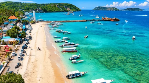toya pakeh beach - klungkung interesting places to visit - bali touristic A tropical coastal view of Toya Pakeh Beach featuring crystal-clear blue waters, colorful snorkeling and diving spots, traditional boats, and a vibrant island atmosphere popular with marine adventure travelers.