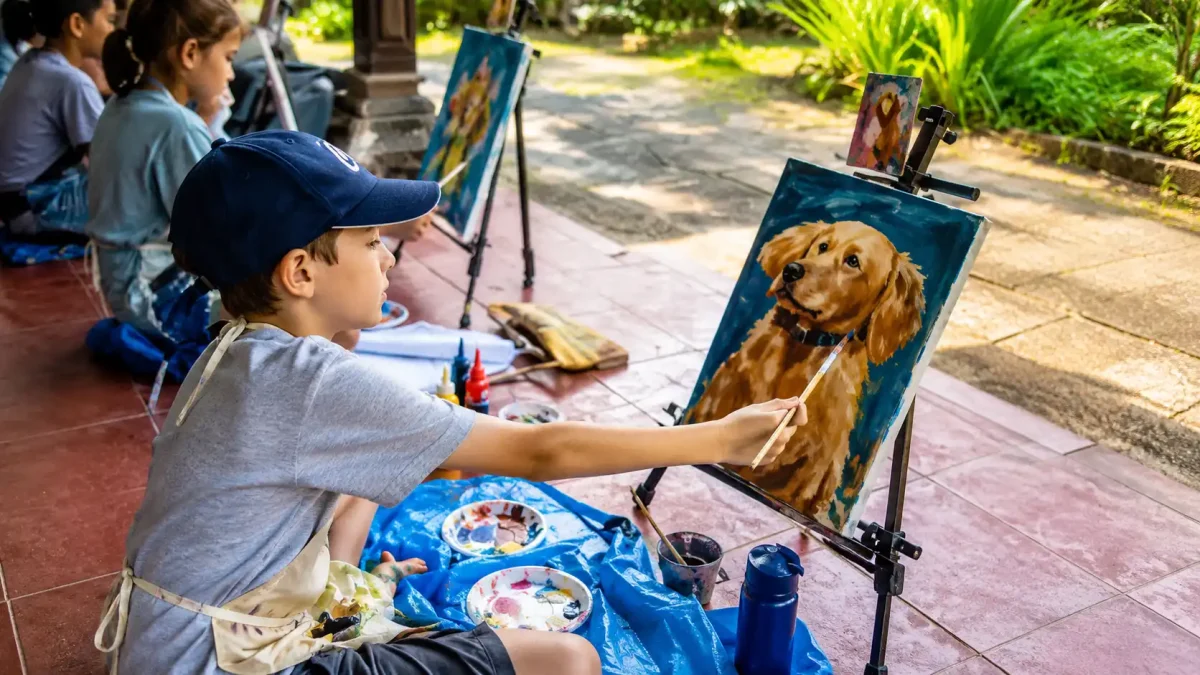 Guests painting in an open-air art studio near Sanur Beach surrounded by tropical scenery.