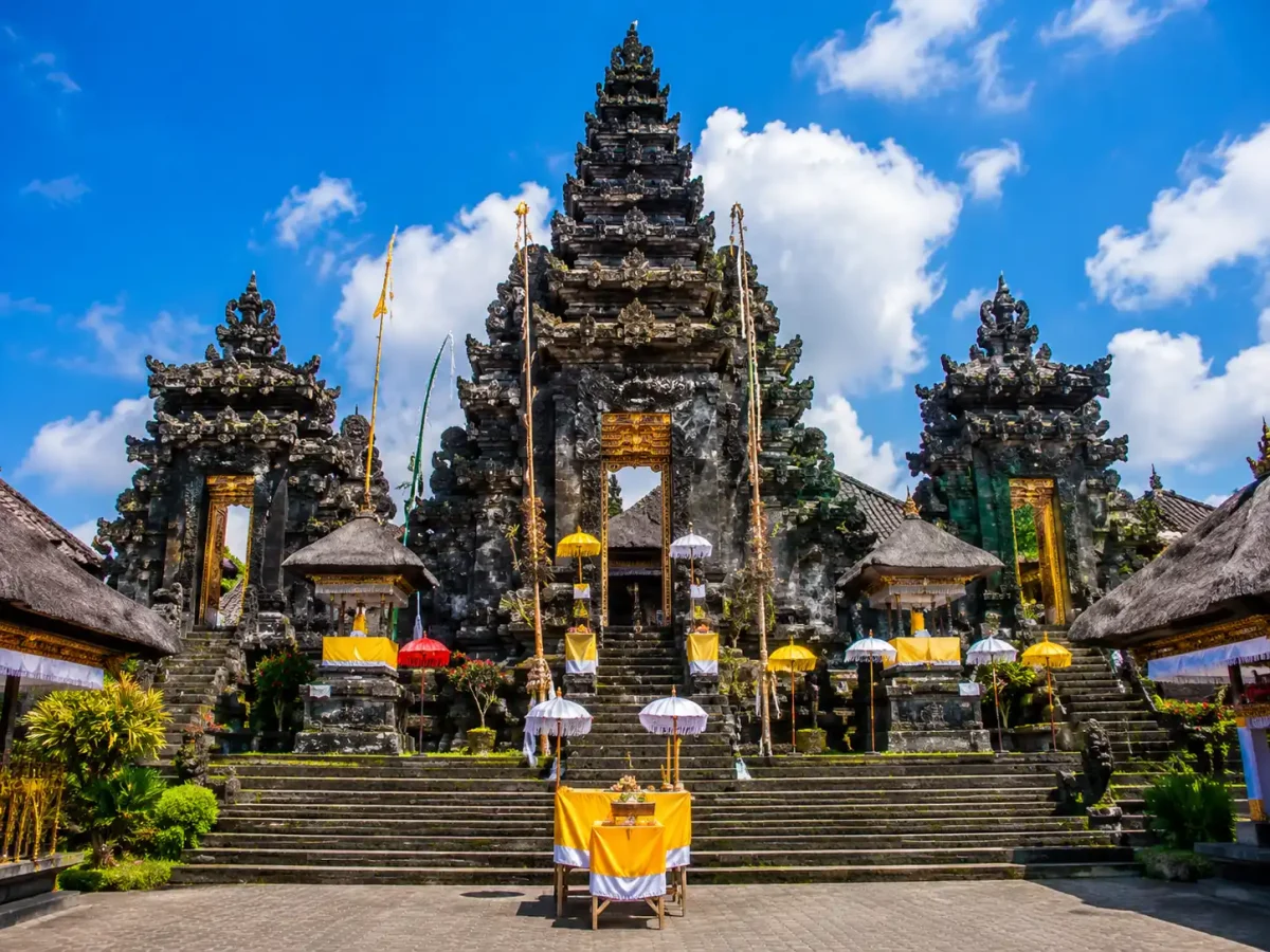 blanjong temple - denpasar interesting places to visit - bali touristic A traditional Balinese ceremony at Blanjong Temple featuring worshippers in colorful ceremonial attire, ornate offerings, temple shrines adorned with penjors, and a peaceful spiritual atmosphere surrounded by lush tropical gardens.