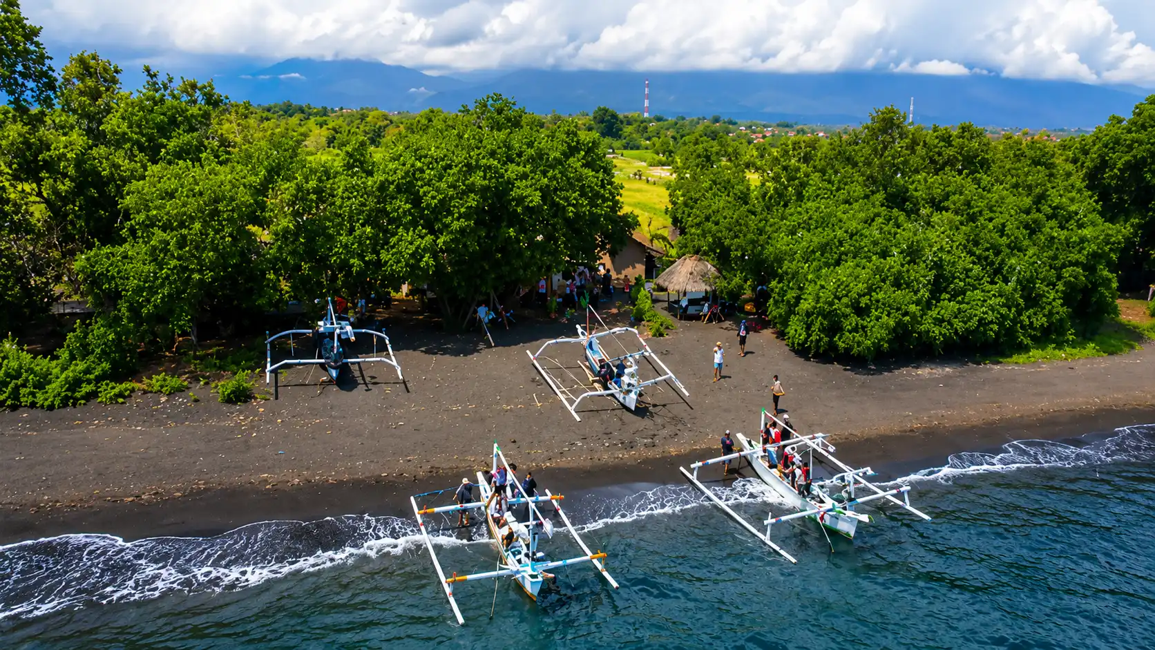 Scenic aerial perspective of Giri Emas Beach with local jukung boats and calm coastal waters in North Bali.
