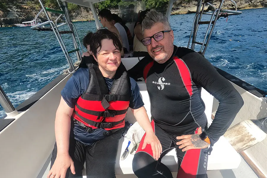 A romantic couple swimming underwater in crystal-clear turquoise ocean water alongside a large, majestic manta ray, a thrilling choice for things to do in bali for couples. | balitouristic.com