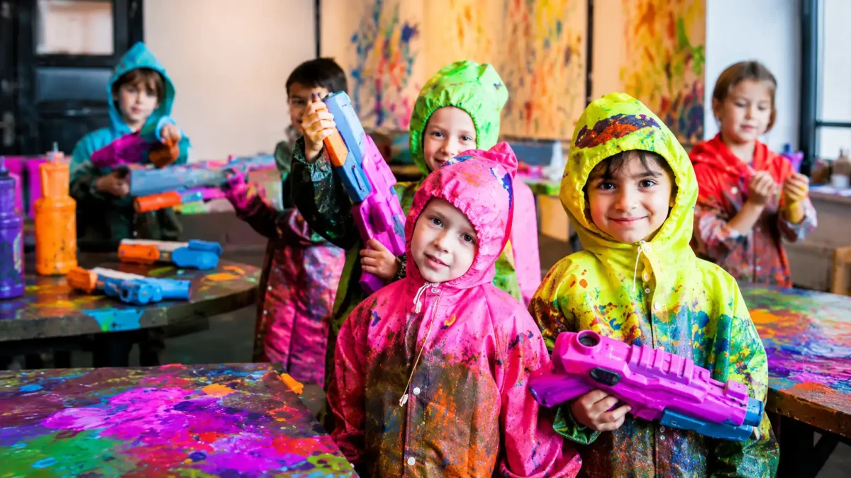 Guests splashing colorful paint with water guns and balloons at Wild Art Bali in Canggu.