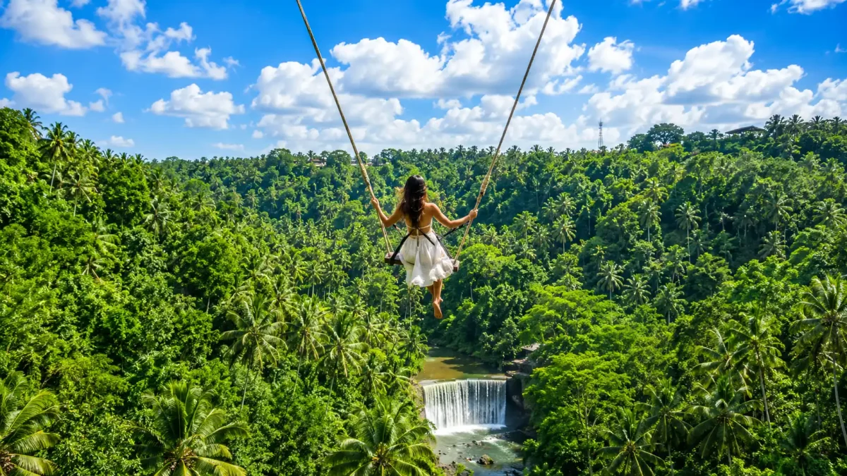 A traveler enjoying a peaceful jungle Bali swing Ubud at Zen Hideaway, soaring above lush tropical forests, river valleys, and swaying palm trees with breathtaking views of Bali’s natural landscape.