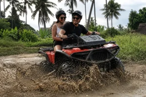A group of people driving green quad bikes along a palm tree trail near a sandy beach.
