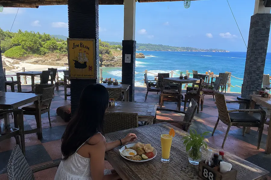 A diner eating Nasi Goreng at a cliffside cafe.