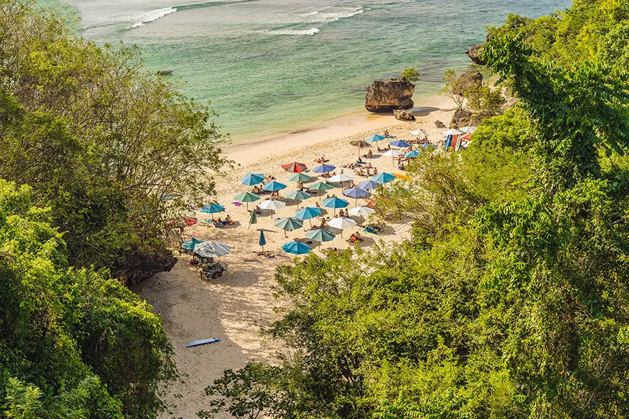 padang padang beach - badung interesting places to visit - bali touristic Scenic view of Padang Padang Beach with white sand, turquoise water, and limestone cliffs in Bali.