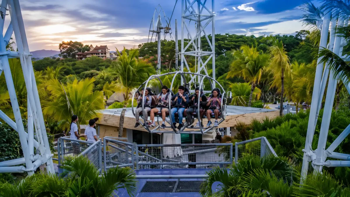 Tourist enjoying the thrilling G Swing Bali above lush tropical jungle.