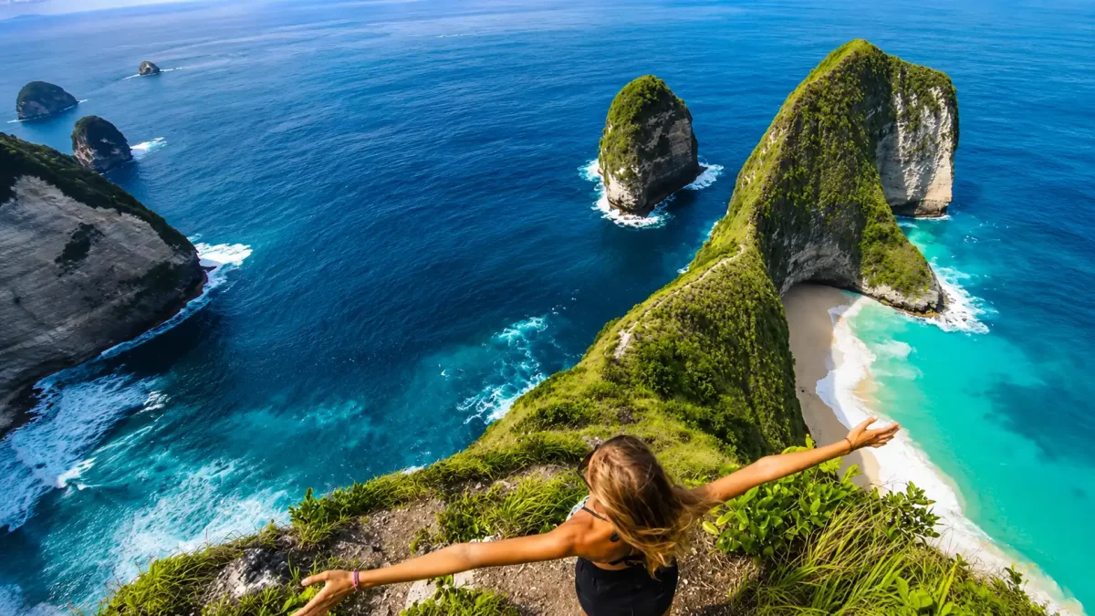 Woman enjoying the breathtaking view of Kelingking Beach from the famous cliff viewpoint in Nusa Penida.