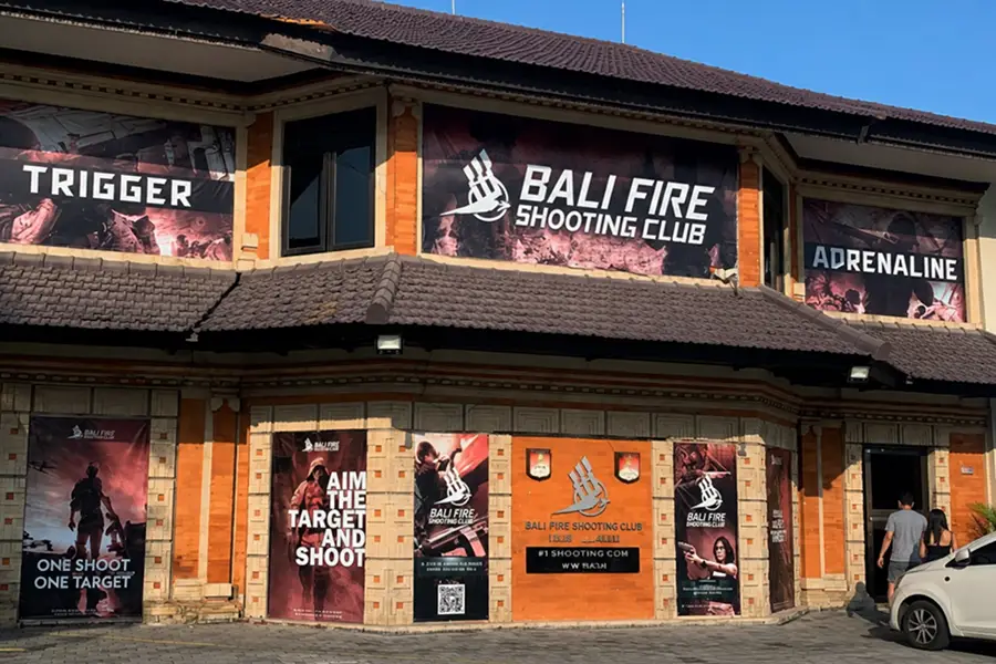 The exterior building facade featuring large promotional banners and traditional Balinese stone architecture.