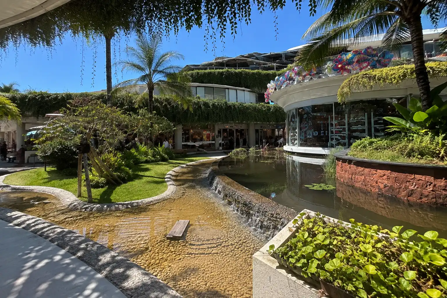 Experience a serene tropical escape. Beachwalk Bali Shopping Center features unique architecture integrated with lush green landscapes and soothing water features.