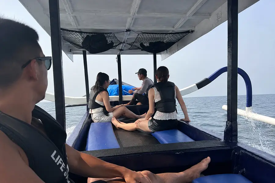 assengers enjoying the trip on a boat Canggu to Uluwatu with ocean views.