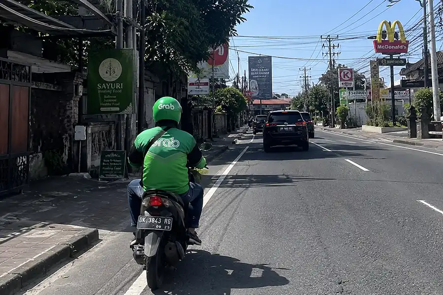 Grab motorbike driver traveling on the road from Canggu to Uluwatu.