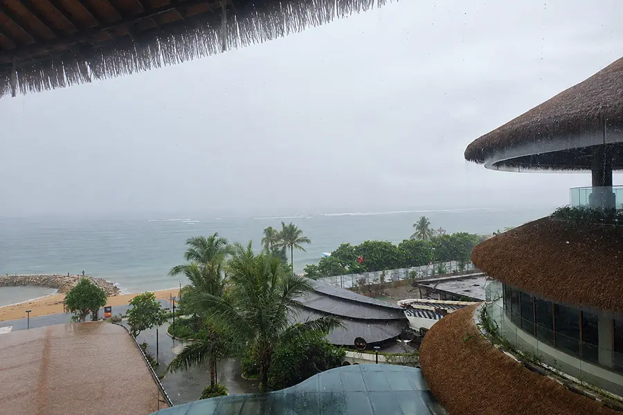 Rainy day views of the beach from a balcony at Icon Bali Mall Sanur.