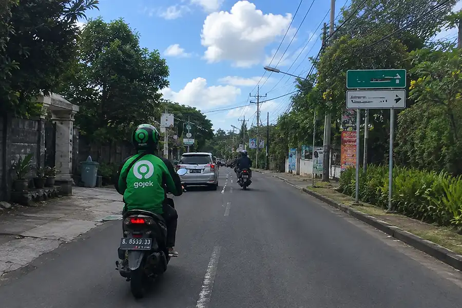 A Gojek motorbike driver riding along the road from Ungasan to Uluwatu.
