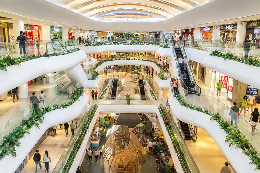 An indoor perspective of the brightly lit shopping corridors in Icon Bali Mall Sanur.