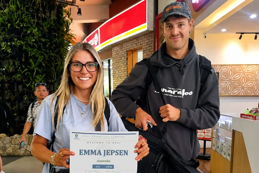 A young tourist couple holding their arrival welcome board inside the airport arrival area.