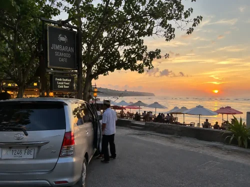 A car parked near Jimbaran Seafood Cafe at sunset