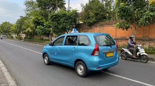Blue taxi operating a comfortable Bali airport transfer to Sanur.