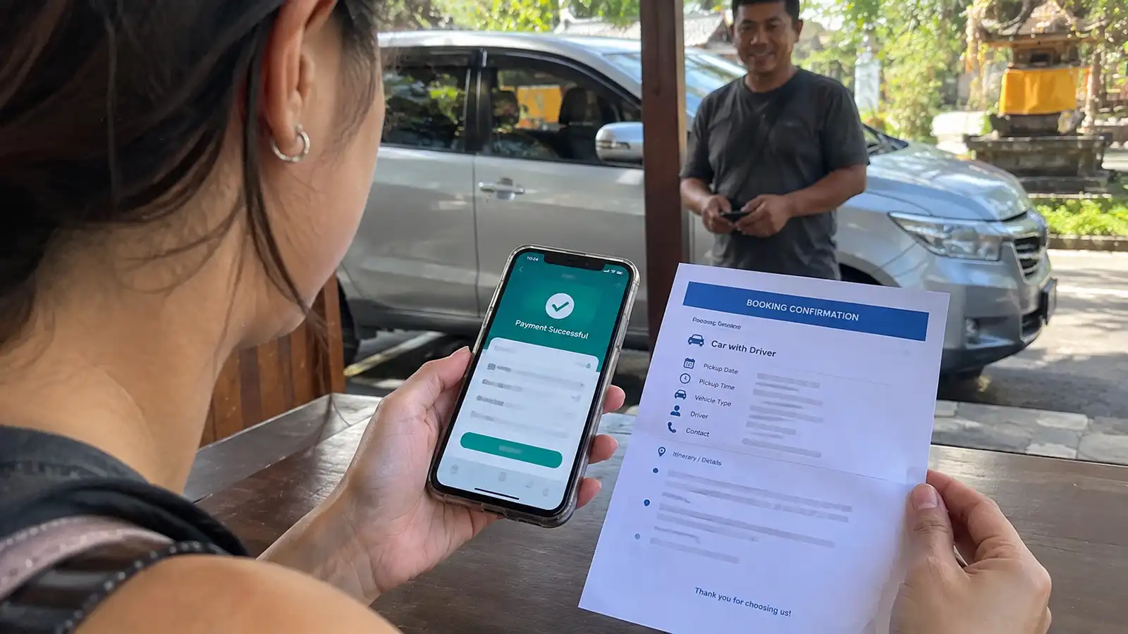 raveller checking a bank transfer payment for a Bali car with driver booking