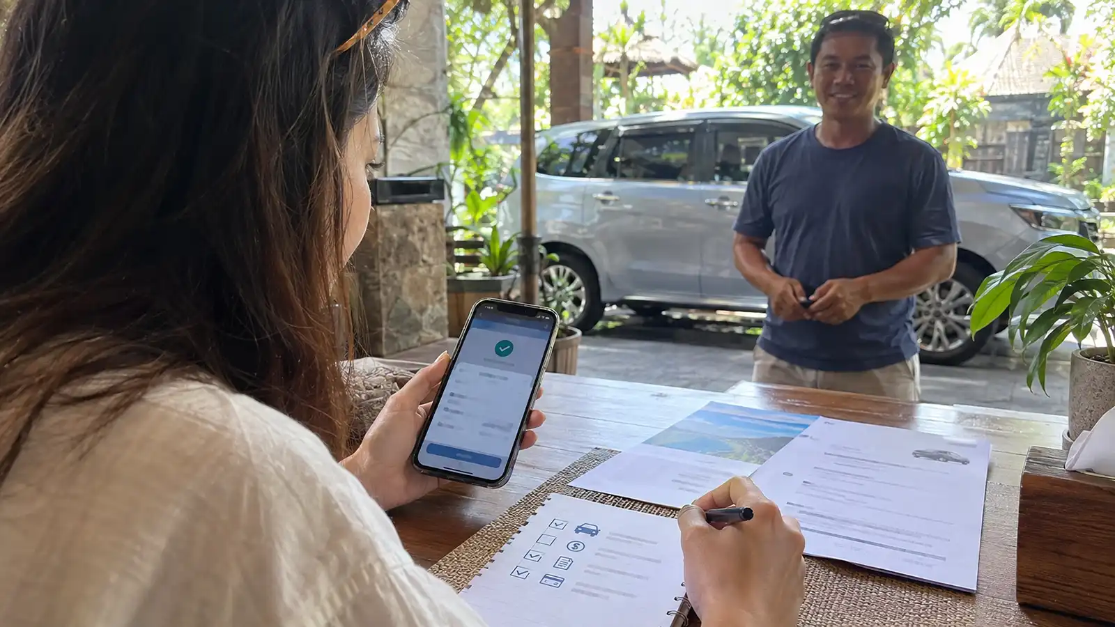 Traveller checking Bali car driver booking details before making payment