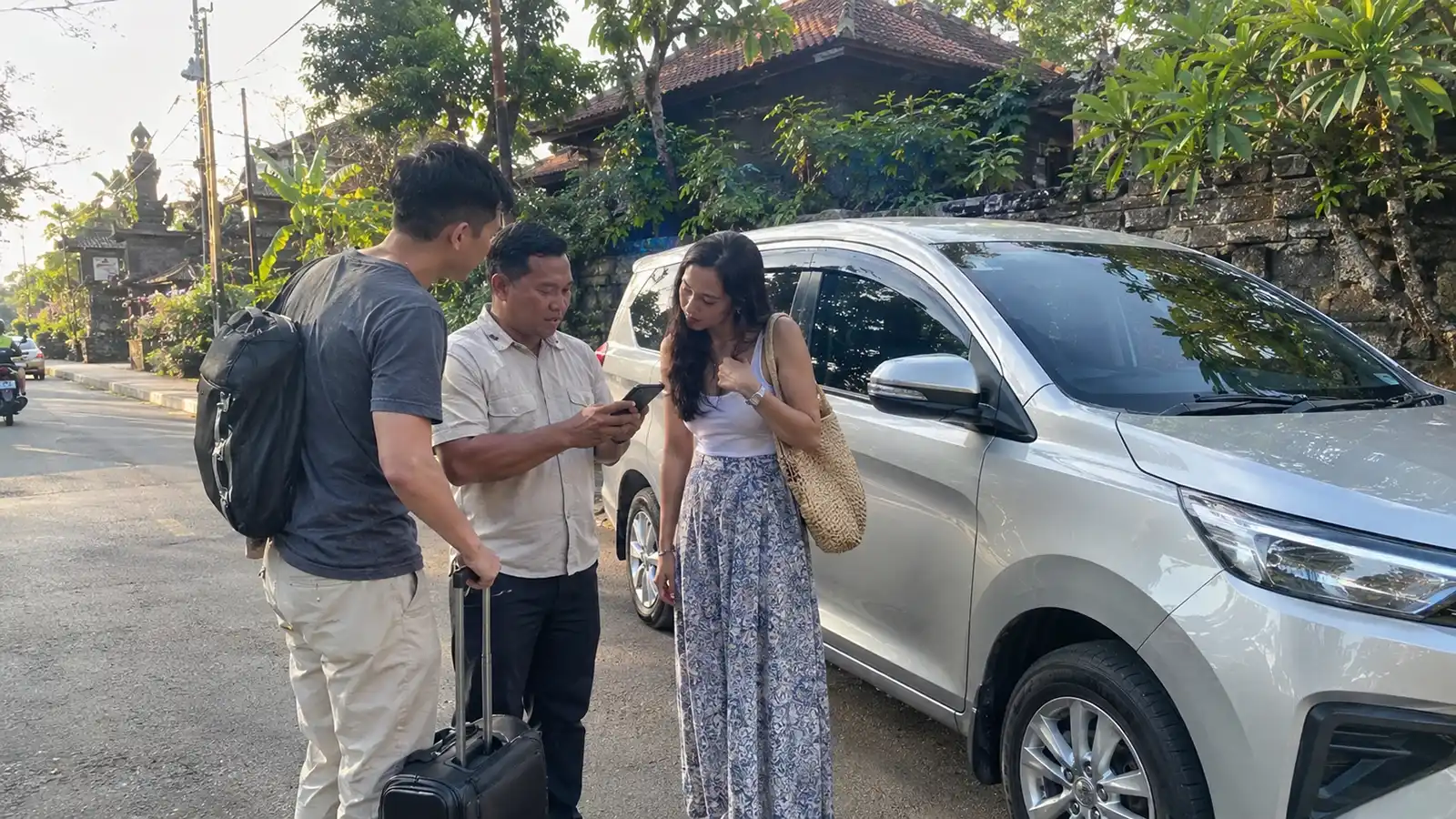 Bali private driver and travellers checking the time beside their vehicle