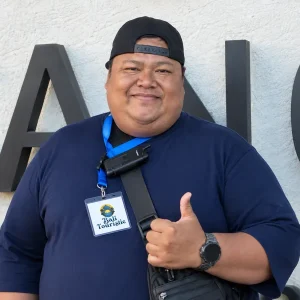 Fendy, Bali Touristic driver with a staff ID card, giving a thumbs up before an airport transfer