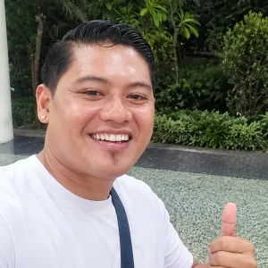 Hendra, friendly Bali private driver, giving a thumbs up before an airport pickup