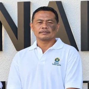 Rian, Bali Touristic driver in a white uniform polo, ready for Ngurah Rai Airport pickups